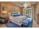 Luxury main bedroom suite with detailed walls, chandelier, large windows, and blue accent furniture at 1400 Alabama Dr, Winter Park, FL 32789