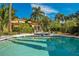 Beautiful pool with fountain feature, surrounded by lush landscaping and palm trees at 1400 Alabama Dr, Winter Park, FL 32789