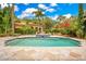 Backyard pool featuring lush landscaping, blue tile trim, and an elegant fountain at 1400 Alabama Dr, Winter Park, FL 32789