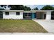 Inviting single-story home with a well-manicured lawn, neutral exterior, and an attached carport at 1416 Bennett Rd, Orlando, FL 32803