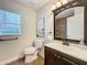 Bathroom featuring a dark vanity, framed mirror and a window to let in light at 1609 River Birch Ave, Oviedo, FL 32765