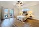 A primary bedroom with laminate floors, a ceiling fan, and French doors leading to the lanai at 1609 River Birch Ave, Oviedo, FL 32765