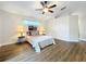 Bedroom with wood laminate floors, ceiling fan, and a decorative window above the bed at 1609 River Birch Ave, Oviedo, FL 32765