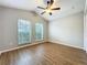 This bedroom features two sunny windows, a ceiling fan, and laminate wood flooring at 1609 River Birch Ave, Oviedo, FL 32765