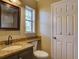 Well-lit bathroom featuring granite countertops, updated fixtures, and a framed mirror at 2055 Jessamine Ct, Deltona, FL 32738