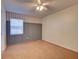 Cozy bedroom featuring neutral carpet, a ceiling fan, and an oversized window at 2055 Jessamine Ct, Deltona, FL 32738