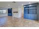 Open living room with tiled floors and blue built-in bookshelves on either side of a doorway at 2055 Jessamine Ct, Deltona, FL 32738