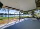 Screened-in porch overlooking a serene lake and lush greenery at 2055 Jessamine Ct, Deltona, FL 32738