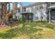 Exterior view of the home's backyard featuring grass and some trees at 2201 Coach House Blvd # 3, Orlando, FL 32812