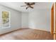 A clean and bright carpeted bedroom featuring a ceiling fan and window that provides natural light at 2201 Coach House Blvd # 3, Orlando, FL 32812