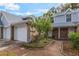 Townhome with a brick facade and light siding featuring an attached garage and a landscaped walkway to the front door at 2201 Coach House Blvd # 3, Orlando, FL 32812