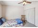 This minimalist bedroom features a ceiling fan and closet, with a colorful quilt for a touch of homestyle at 2706 Cranmoor Dr, Kissimmee, FL 34758