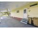 Carport area featuring a white front door, stairs and exterior with painted yellow siding at 2706 Cranmoor Dr, Kissimmee, FL 34758