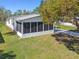 Aerial view of home exterior with screened lanai, white exterior, mature trees, and expansive front lawn at 2706 Cranmoor Dr, Kissimmee, FL 34758