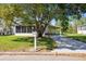 Charming single-story home featuring a well-maintained front yard, large shade tree, and a convenient covered carport at 2706 Cranmoor Dr, Kissimmee, FL 34758