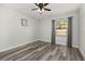 An empty bedroom with wood-look floors, a ceiling fan, and a large window at 2740 Courtland Blvd, Deltona, FL 32738