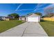 Single-story home with a green lawn, a long driveway, and an attached two-car garage at 2740 Courtland Blvd, Deltona, FL 32738