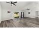 Spacious living room featuring modern wood-look flooring, ceiling fan, and sliding glass door to back yard at 2740 Courtland Blvd, Deltona, FL 32738