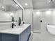 Modern bathroom showcasing double sinks, marble countertops, and a glass-enclosed shower, plus a soaking tub at 2902 Egrets Landing Dr, Lake Mary, FL 32746