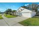 Charming white single-story home featuring a two-car garage, manicured lawn, and inviting curb appeal at 2902 Egrets Landing Dr, Lake Mary, FL 32746