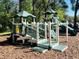 White and green playground structure with slides and stairs in a wooded area at 2902 Egrets Landing Dr, Lake Mary, FL 32746