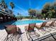 Community pool featuring lounge chairs, palm trees and nearby pavilion on a bright sunny day at 2902 Egrets Landing Dr, Lake Mary, FL 32746