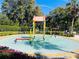 Community splash pad with colorful water features in a circular pool surrounded by landscaping at 2902 Egrets Landing Dr, Lake Mary, FL 32746