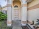 Inviting front entrance with decorative columns, arched doorway, and neatly maintained landscaping at 3100 Tall Grass Pl, Kissimmee, FL 34743