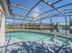 A refreshing pool with a screened enclosure offers scenic water views, creating a private outdoor oasis at 3100 Tall Grass Pl, Kissimmee, FL 34743