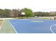 A vibrant blue basketball court provides a fun recreational area surrounded by lush greenery at 3108 Dark Sky Drive, Harmony, FL 34773