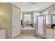 Bright bathroom featuring a bathtub with tile surround, a glass enclosed shower, and a white vanity at 3172 Bayview Ln, St Cloud, FL 34772