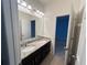 Bathroom featuring a dual sink vanity with granite countertops and a large mirror for daily grooming at 3942 Green Sabal Dr, Orlando, FL 32824