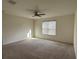 Spacious bedroom featuring a ceiling fan, plush carpeting, a window for natural light, and neutral walls at 3942 Green Sabal Dr, Orlando, FL 32824