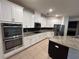 Bright kitchen featuring stainless steel appliances, granite countertops, white cabinetry, and a mosaic backsplash at 3942 Green Sabal Dr, Orlando, FL 32824