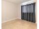 Simple bedroom with tiled floors and beige walls, featuring a large window for natural light at 415 N Halifax Ave # 216, Daytona Beach, FL 32118