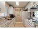 Galley kitchen with white cabinets, granite counters, and modern appliances in a bright space at 415 N Halifax Ave # 216, Daytona Beach, FL 32118