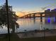 Waterfront sunset view featuring bridge and picnic area at 415 N Halifax Ave # 216, Daytona Beach, FL 32118