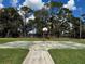 Outdoor basketball court with a standard hoop and a well-maintained surface surrounded by lush greenery and tall trees at 4407 Lake Lawne Ave, Orlando, FL 32808