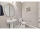 Bathroom featuring a pedestal sink, toilet, and decorative mirror with neutral color palette at 5607 Western Sky Pl, St Cloud, FL 34771