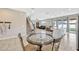 Open dining area with a table and four chairs, a view into the living room, and a kitchen island at 5607 Western Sky Pl, St Cloud, FL 34771