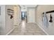 Hallway with light gray tile flooring, coat rack, and a view into an adjacent room at 5607 Western Sky Pl, St Cloud, FL 34771