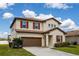 Two-story home featuring a two car garage, neutral beige stucco and warm brown trim and red shutters at 5607 Western Sky Pl, St Cloud, FL 34771