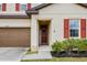 Close-up of the front door with a dark brown door, sidelight, and landscaping at 5607 Western Sky Pl, St Cloud, FL 34771