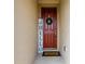 Charming front door with a welcoming wreath and stylish doormat, inviting guests inside at 5607 Western Sky Pl, St Cloud, FL 34771