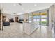 Kitchen island with a granite countertop, sink, white cabinets, and a view into the living room at 5607 Western Sky Pl, St Cloud, FL 34771