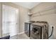 Well-equipped laundry room with modern washer and dryer, storage shelf, and white door at 5607 Western Sky Pl, St Cloud, FL 34771