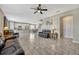 Spacious living room with a view into kitchen and dining area, featuring tile floors and black leather seating at 5607 Western Sky Pl, St Cloud, FL 34771