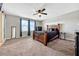 Spacious main bedroom with a ceiling fan, carpet flooring, and lots of natural light through the windows at 5607 Western Sky Pl, St Cloud, FL 34771