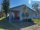 Charming home featuring light siding, red front door, and quaint covered porch at 586 N 8Th St, Eagle Lake, FL 33839