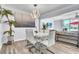 Dining room featuring a modern chandelier, sleek white table, and view of a cozy outdoor seating area at 758 Orchid Dr, Davenport, FL 33897